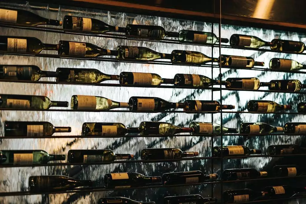 Artistic display of wine bottles on a glass wall. Ideal for wine shop themes.