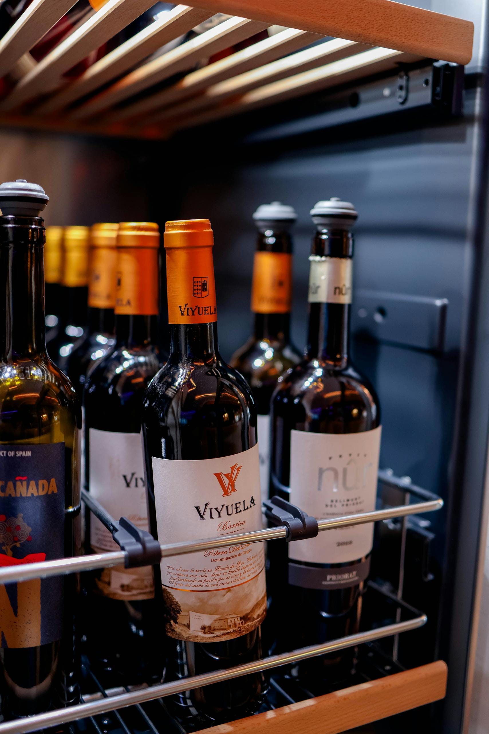 A selection of wine bottles stored in a refrigerator, ideal for preserving wine quality.