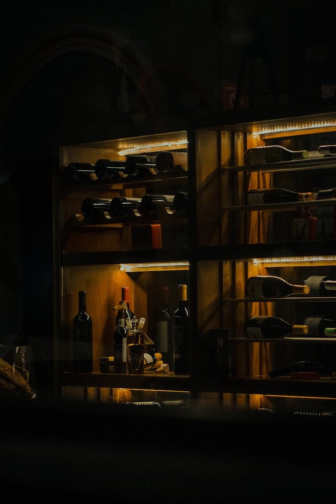 A stylish wine rack with various bottles showcased in cozy lighting in Mérida, Mexico.