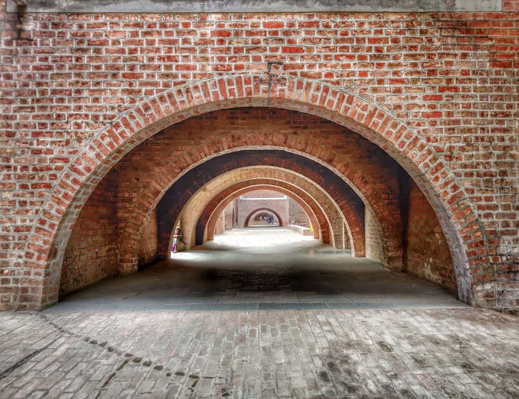 Archway tunnel at Indian Institute of Management, Ahmedabad, showcasing intricate brickwork design.