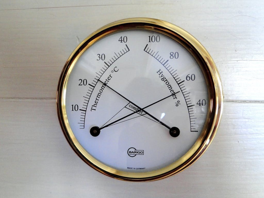 Close-up of a round analog display showing temperature and humidity.