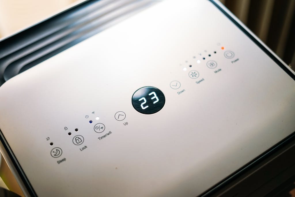 Close-up of a sleek air conditioner control panel displaying temperature.