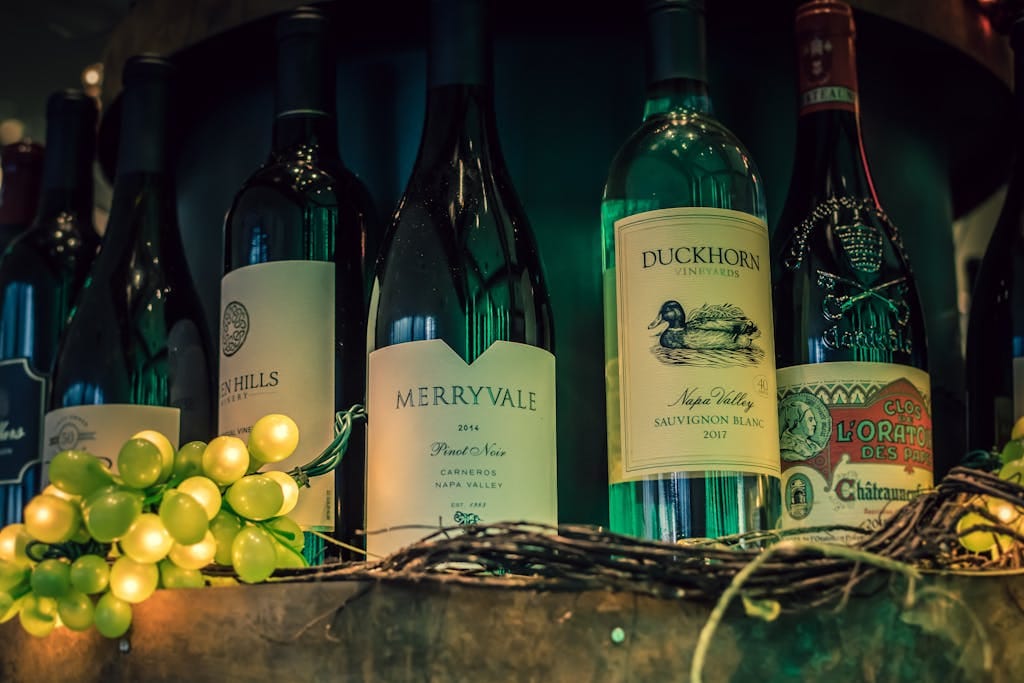 Close-up of wine bottles with green grapes, perfect for wine enthusiasts.