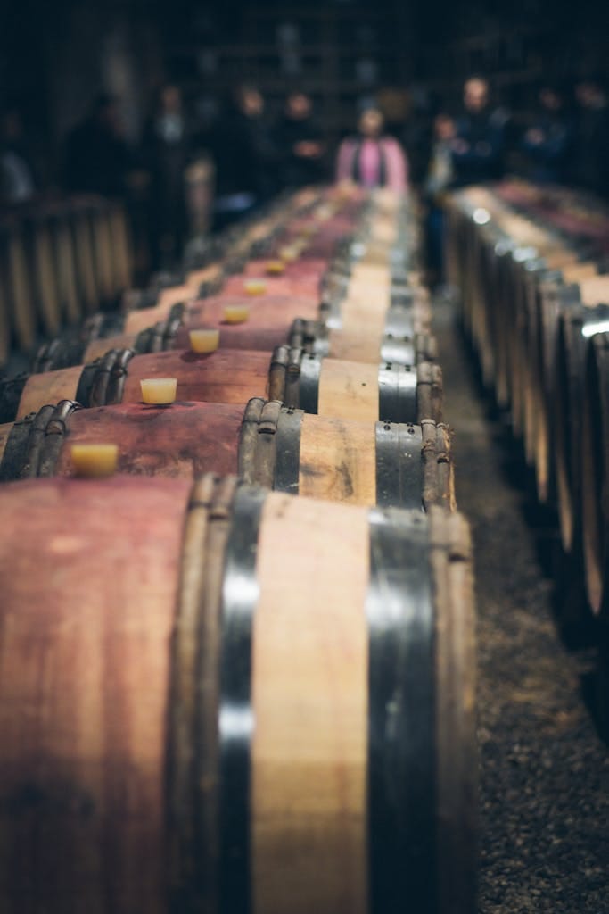 Close-up of wooden wine barrels lined up in a cellar, perfect for aging wine.