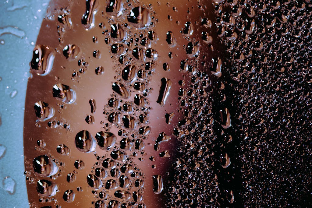 Detailed macro image of water droplets creating an abstract pattern on glass.