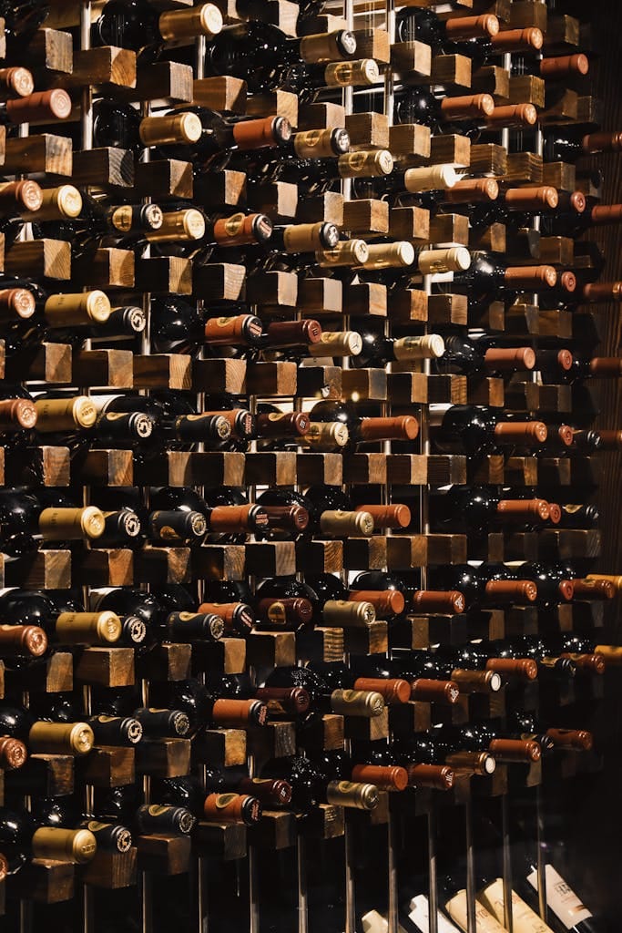Vertical display of wine bottles on wooden racks, ideal for bars or cellars.